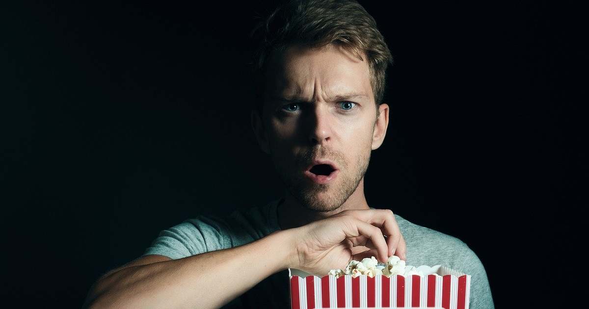 psychology of horror fans - man eating popcorn