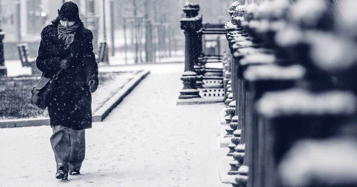 resilience to the cold - woman walking in the city snow