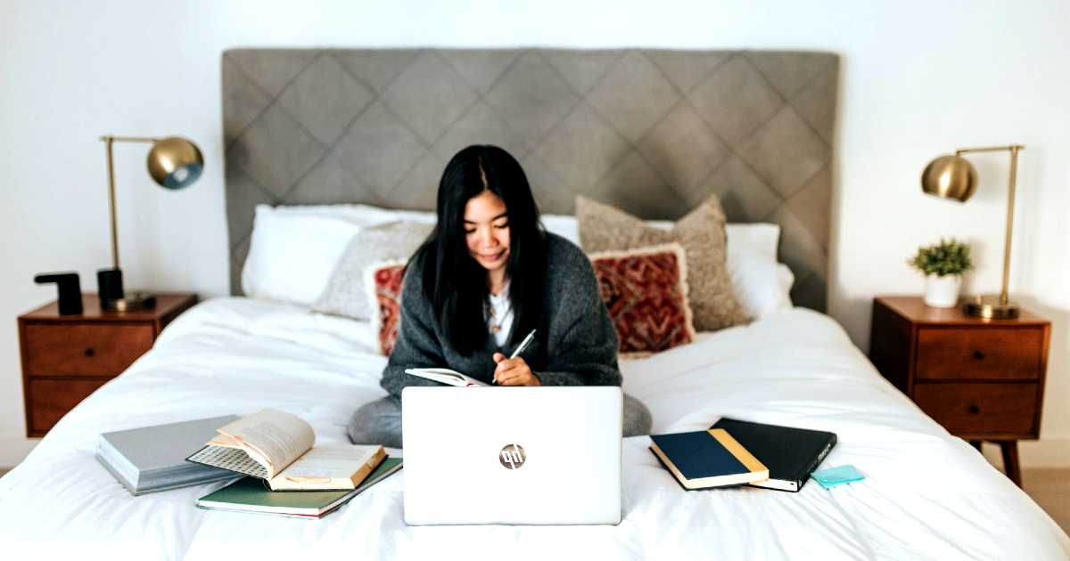 working from home - woman with laptop on bed