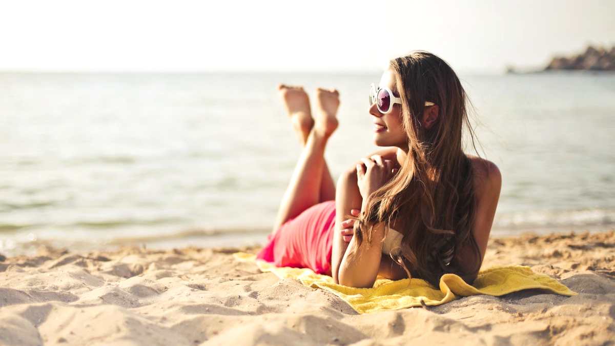 sunbathing aging app - woman on beach