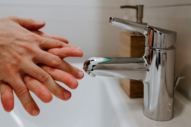 paper towel vs hand dryer - washing hands in sink  
