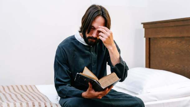 Engelszahlen und die Bibel - Mann liest auf dem Bett